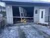 Åstedet er fortsatt sperret av med politibånd. Her ser vi hvilke ødeleggelser som oppstod da en bil braste inn i porten på garasjen natt til lørdag. En mann i 20-åra er alvorlig skadet.