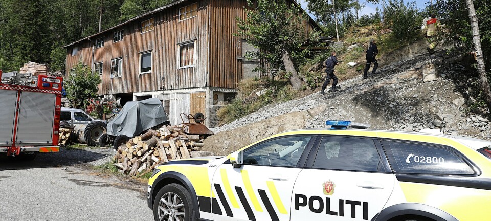 Fyrte bål tett ved bygning og vegetasjon